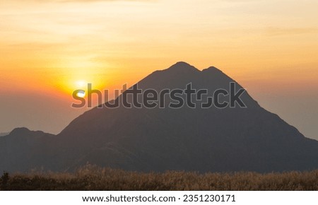 Beautiful sunset of Lantau Peak, looking from Sunset Peak in Autumn, full around with golden silver grasses (miscanthus), Lantau Island, Hong Kong