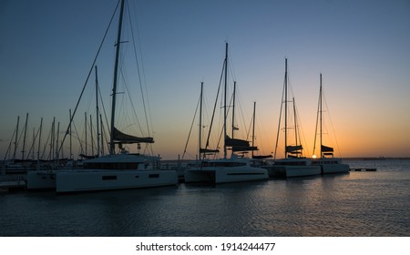 beautiful sunset in a marina surrounded by yachts and sailboats - Powered by Shutterstock