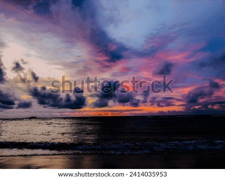 Beautiful sunset at the ocean. A vibrant sky filled with colorful clouds in the eve. Ocean, sunset, nature beauty and coastal concept image. 