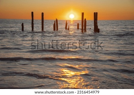 Beautiful sunset on the sea with the rest of old jetty, horizontal picture
