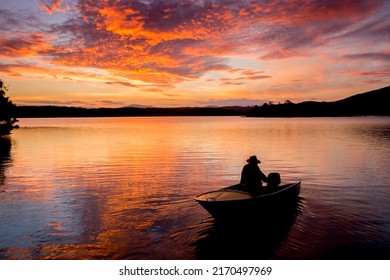 Beautiful sunset on tranquility lake with fishing boat silhouette. Water reflections stunning nature background - Powered by Shutterstock