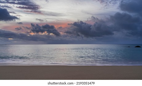 Beautiful sunset on a tropical island. In the sky, illuminated with scarlet, dark blue clouds. Calm turquoise ocean. Foam of waves on the sand. Seychelles. Mahe. Beau Vallon beach - Shutterstock ID 2193351479
