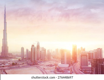 Beautiful sunset over Dubai city, amazing cityscape lit with warm sun light, contemporary new modern architecture, view from above on a luxury property of United Arab Emirates