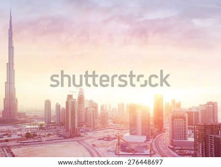 Beautiful sunset over Dubai city, amazing cityscape lit with warm sun light, contemporary new modern architecture, view from above on a luxury property of United Arab Emirates