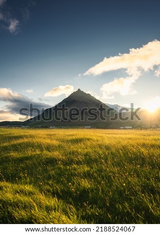 Beautiful sunset over Stapafell mountain and glowing meadow in Arnarstapi village on summer at Iceland