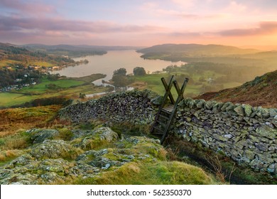 Beautiful sunset over Windermere in the Lake District with a stile and stone wall in the foreground. - Shutterstock ID 562350370