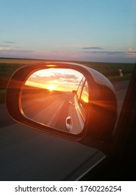Beautiful Sunset In Rearview Mirror Of Automobile. Reflection Of Road At The Car Side Mirror.