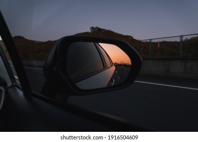 Beautiful Sunset In Sideview Car Mirror On Mountain Road