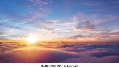 Beautiful sunset sky above clouds with dramatic light. Cabin view from airplane - Powered by Shutterstock