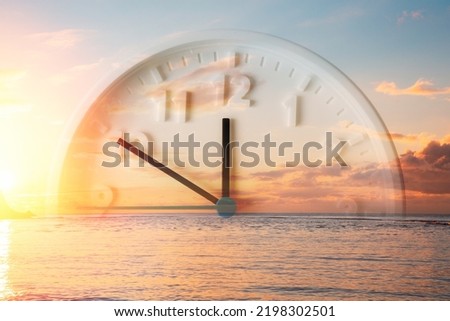 Beautiful sunset sky, ocean and close up of clock. Double exposure. Copy space. Concept of Daylight Savings Time.