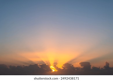 A beautiful sunset with the sun's rays streaming through clouds, casting a warm, golden light across the sky.