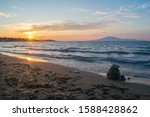 A beautiful sunset at Tsilivi beach on the Greek island of Zakynthos, with the Ionian sea and Mount Ainos, the tallest peak of Kefalonia island in the background