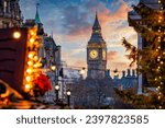 Beautiful sunset view of the Big Ben Clocktower in London, England, with the fairy lights from the Trafalgar Square Christmas market in front