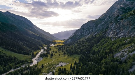 Beautiful sunset with a view of the green gorge and the river. coniferous trees, forests, lots of grass are all around. A seething gray river. Clouds in the sky. The rays of the sun. Steep cliffs - Powered by Shutterstock