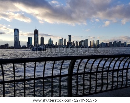 A beautiful sunset from the view of New York City overlooking the harbor. Beautiful cityscape of NewJersey on the opposite side of the river.
