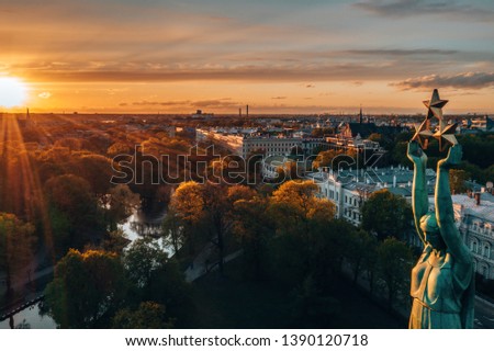 Beautiful sunset view over Riga by the statue of liberty - Milda in Latvia. The monument of freedom. People gathering around the monument for the concert.
