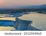 Beautiful sunset view of Pamukkale travertines, with the warm golden light reflecting off the terraced pools. Pamukkale, Denizli, Turkey (Turkiye)