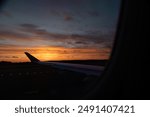 A beautiful sunset view through the airplane window flying from Sweden to Latvia. Travel wonderlust scenery.