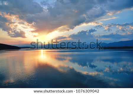 Beautiful Sunset.Sun,lake.Sunrise Landscape.Beauty in Nature.Blue Sky. Amazing Colorful Clouds.Water Reflections.Magic Artistic Wallpaper.Creative Orange Background.Tranquil Natural Art Photography.