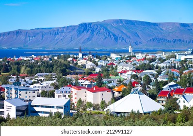 Beautiful super wide-angle aerial view of Reykjavik, Iceland with harbor and skyline mountains and scenery beyond the city, seen from the observation tower of Hallgrimskirkja Cathedral. 