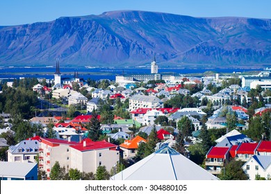 Beautiful super wide-angle aerial view of Reykjavik, Iceland with harbor and skyline mountains and scenery beyond the city, seen from the observation tower of hallgrimskirja 