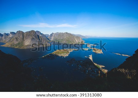 Beautiful super wide-angle summer aerial view of Reine, Norway, Lofoten Islands, with skyline, mountains, famous fishing village with red fishing cabins
