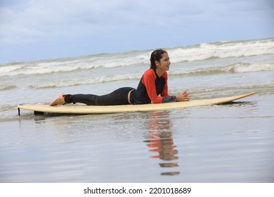 Beautiful Surfer Asian Girl On The Beach . Asian Woman Playing Surf On Sunlight.