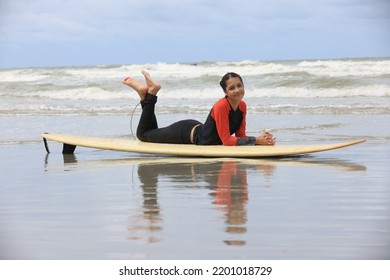 Beautiful Surfer Asian Girl On The Beach . Asian Woman Playing Surf On Sunlight.