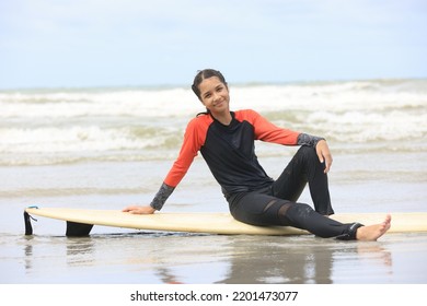 Beautiful Surfer Asian Girl On The Beach . Asian Woman Playing Surf On Sunlight.