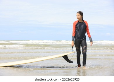 Beautiful Surfer Asian Girl On The Beach . Asian Woman Playing Surf On Sunlight.