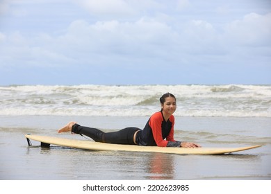 Beautiful Surfer Asian Girl On The Beach . Asian Woman Playing Surf On Sunlight.