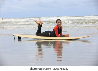 Beautiful Surfer Asian Girl On The Beach . Asian Woman Playing Surf On Sunlight.