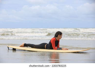 Beautiful Surfer Asian Girl On The Beach . Asian Woman Playing Surf On Sunlight.