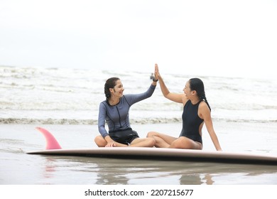 Beautiful Surfer Asian Girl On The Beach . Asian Woman Playing Surf On Sunlight.