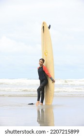 Beautiful Surfer Asian Girl On The Beach . Asian Woman Playing Surf On Sunlight.