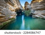 Beautiful surroundings of a waterfall called Salto del Usero in Bullas, Murcia, Spain. Blue and crystalline waters under a yellow rock cave