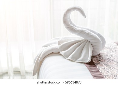 Beautiful Swan From White Bath Towel Decorate On Bed Corner And Soft Sunlight In Background, Nice Greeting From Hotel.