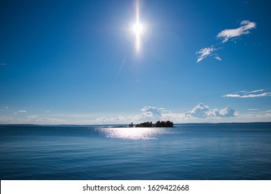 Beautiful Swedish Summer Photo With Blue Sky And Blue Water And A Small Island Centered