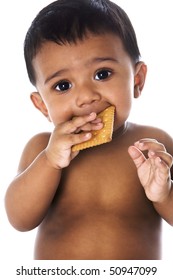 Beautiful Sweet Indian Baby With Big Eyes Eating A Cookie, Isolated On White Background.