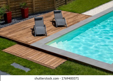 beautiful swimming pool and exotic wooden terrace with sunbath chair - Shutterstock ID 1769400371