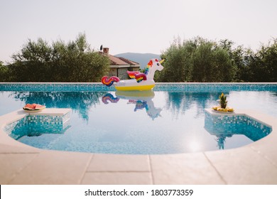 Beautiful Swimming Pool With Inflatable Toy Pool Floating Unicorn. Summer Vacation Time With Fun Beach Floaties In Swimming Pool. No People.