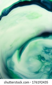 Beautiful swirls of blue and green ink in liquid, with room for text.