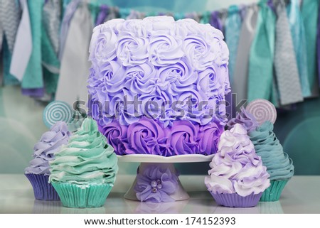 Beautiful table with cake and cupcakes in aqua and purple