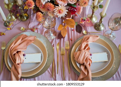 Beautiful Table Setting With Autumn Flowers, Orange And Pink Napkins And Burning Candles. Autumn Wedding Concept