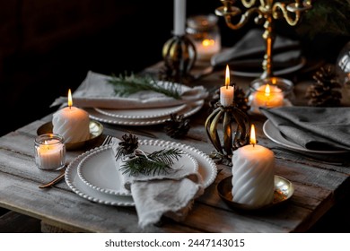 Beautiful table setting for family Christmas dinner at home. Cozy atmosphere, candlelight. Wine glasses, vintage chandelier, elegant interior. Fir tree branches, wooden furniture, dark, bokeh - Powered by Shutterstock