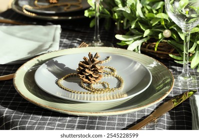 Beautiful table setting with pine cone and mistletoe branches at home, closeup. Christmas celebration