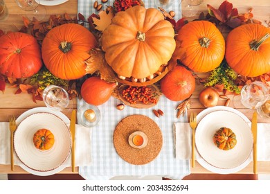 Beautiful Table Setting With Pumpkins And Autumn Leaves In Dining Room