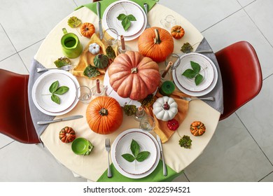 Beautiful table setting with pumpkins in dining room
