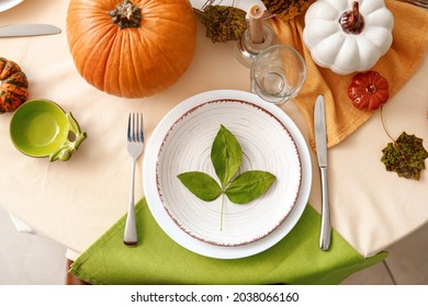 Beautiful table setting with pumpkins in dining room