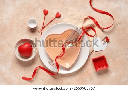 Beautiful table setting with red heart and candles on beige background. Valentine's Day celebration